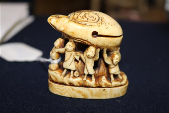 A carved ivory of figures under a crab